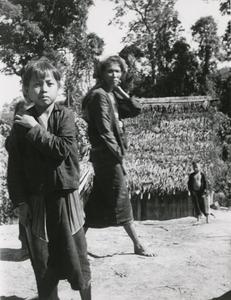 A young boy and woman in a Black Lahu (Lahu Na) village in Houa Khong Province