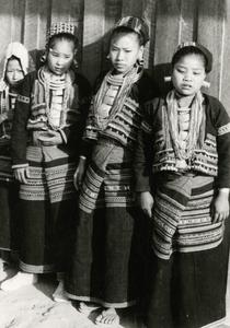 Four Yellow Lahu (Lahu Shi) young women stand in traditional dress in the village of Nam Kheung in Houa Khong Province