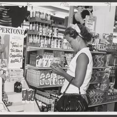 A woman selects a suntan lotion product