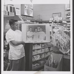 A pharmacist holds a photo of pharmacy staff at a drugstore