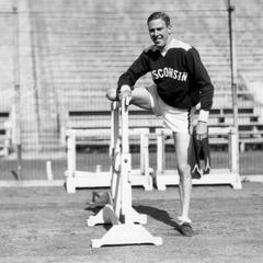 Charles McGinnis posing at a high hurdle.