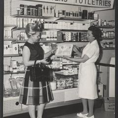 Two women stand in the children's toiletries section of drugstore