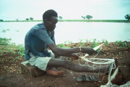 Man Preparing Fish Net by the River