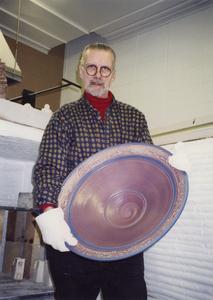 Art professor Tom Gross holding a ceramic bowl