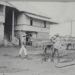 Two men operating a saw mill