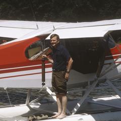 John J. Magnuson standing on float of plane