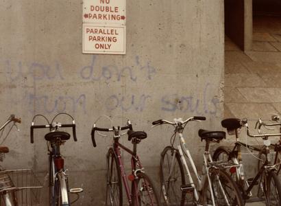 "You don't own our souls" graffiti in front of bikes