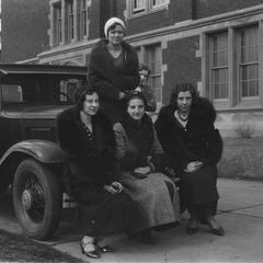 Female students sitting on car