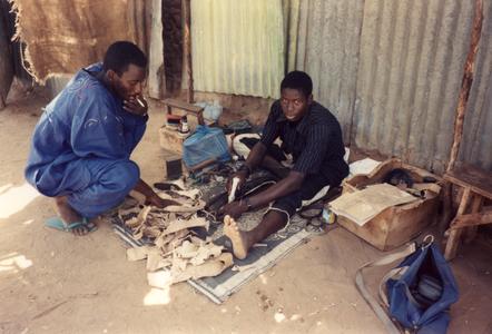 Leatherworker Prepares Straps to Hold Strings of the Ngoni