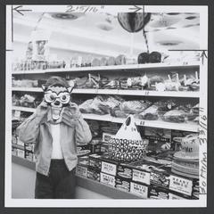 Child tries on a wolf Halloween mask in a drugstore