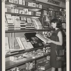 A shopper examines items in a drugstore stationery display