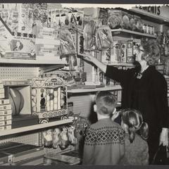 A woman and two children look at toys in the toy department