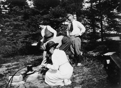 Carl Leopold Jr. and others around campfire at Les Cheneaux