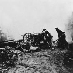 Japanese soldiers firing a light gun along a railway.