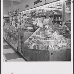 A saleswoman stands at a candy display in a drugstore