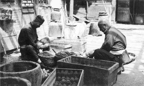 Two Chinese men making thousand-year old eggs.