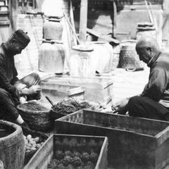 Two Chinese men making thousand-year old eggs.