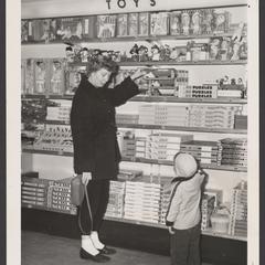 A woman and a young child view toys in a toy display