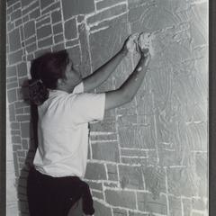 Student applying plaster to wall in theater lab