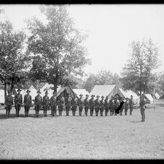 Soldiers in formation in front of tent camp