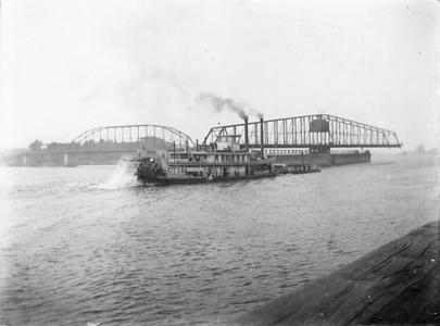 Sternwheel side view of the Kit Carson pushing a barge on the Mississippi River