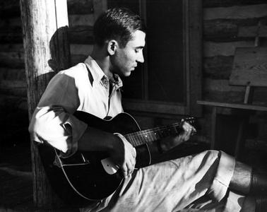 Starker Leopold with guitar at Missouri cabin