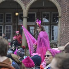 Woman dressed in pink garb marching