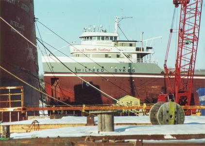 The Wilfred Sykes behind a crane