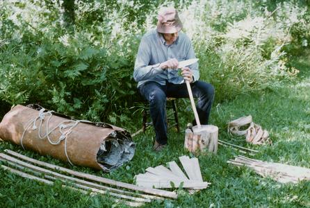 Earl Nyholm splits cedar for a birchbark canoe