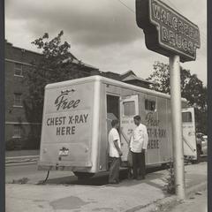 Two men stand outside a mobile X-ray next to a Walgreens