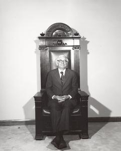 H. Edwin Young seated in the UW "President's Chair"