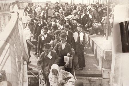 People disembarking in America from an immigrant ship