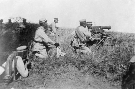 Chinese soldiers led by an officer carrying a machine gun.