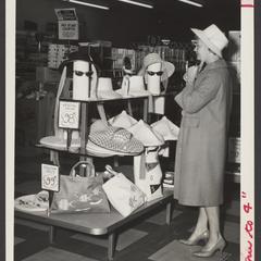 A woman tries on a straw hat at a summer merchandise display