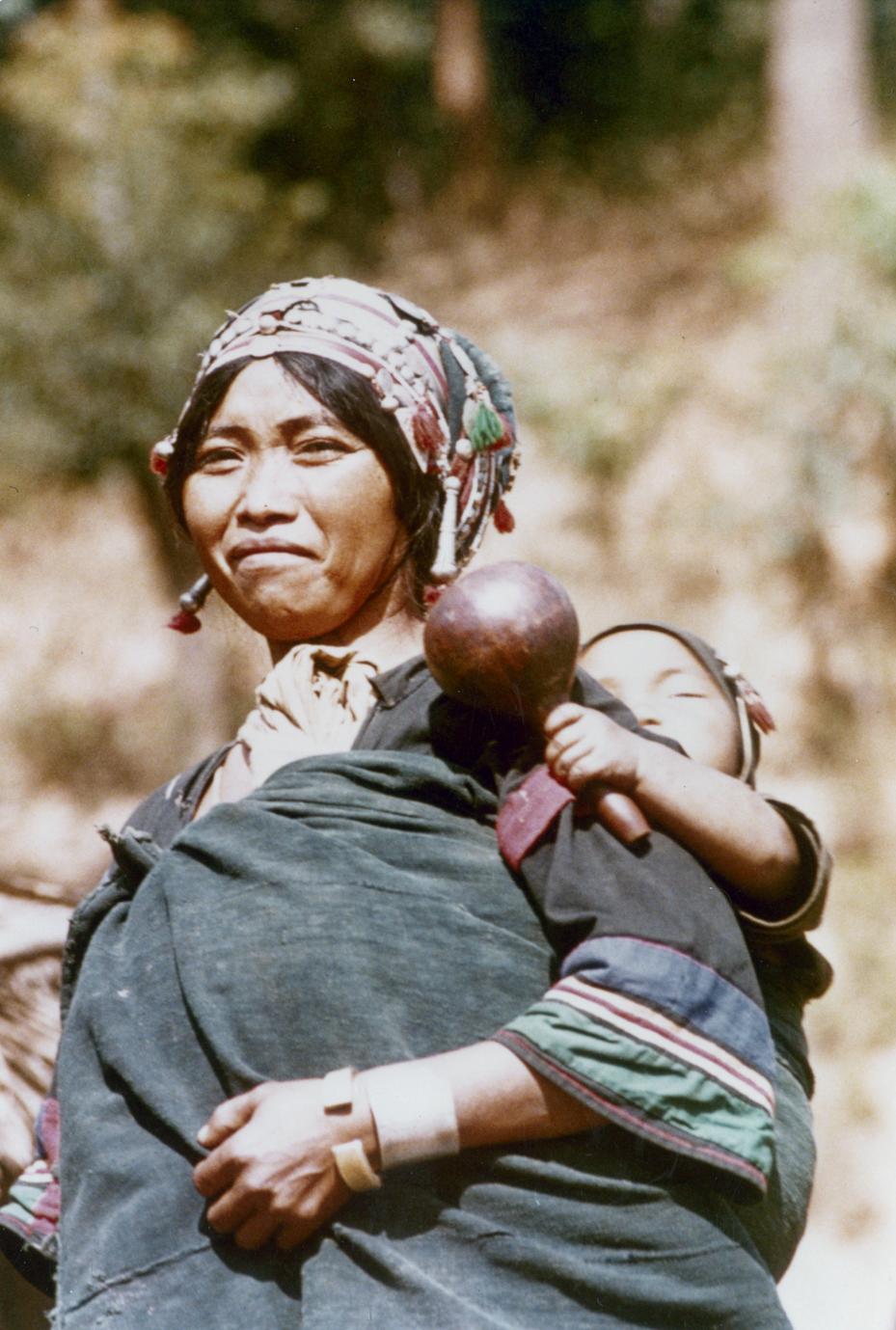 An Akha woman with baby and gourd rattle at the village of Sobloi in Houa Khong Province