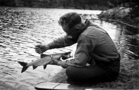 Cleaning fish at water's edge, Boundary Waters, August 1924
