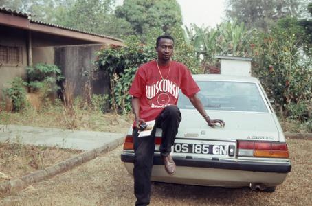 Bodunde Motoni leaning against car