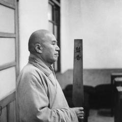 The Jianxiang 監香 meditation patrol makes a circuit carrying the board in front of him.