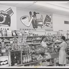Two saleswomen work at a drugstore tobacco counter