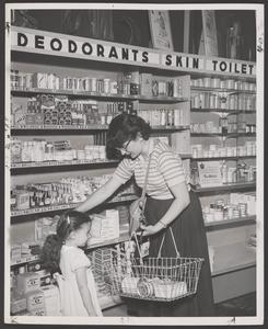 A shopper and her daughter select merchandise at a drugstore