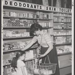 A shopper and her daughter select merchandise at a drugstore