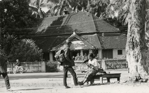 A soldier stands and talks with his wife in the city of Luang Prabang in Luang Prabang Province