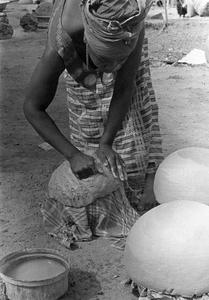 Woman Working Clay of Rounded Pot