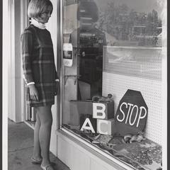 A young woman looks at a fall window display