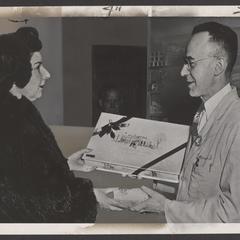 A woman receives a box of chocolates from a pharmacist