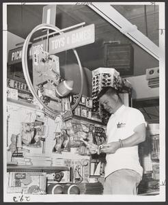 A salesman views a toy display in a drugstore