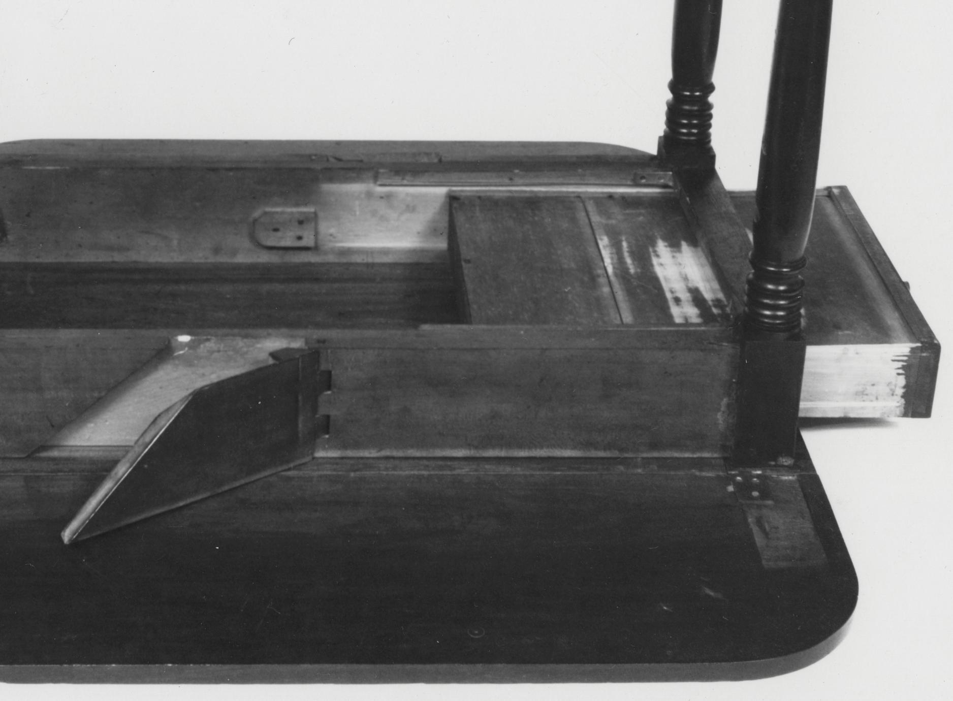 Black and white photograph of the sliding drawer of a breakfast table.