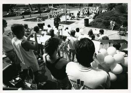 Stout Jazz Band performing outside for students, Memorial Student Center in the background, Spring 1990