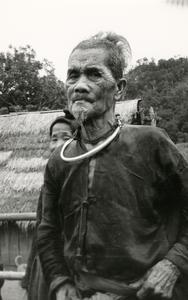 An elderly Blue Hmong (Hmong Njua) man stands in a Hmong village in the vicinity of Muang Vang Vieng in Vientiane Province