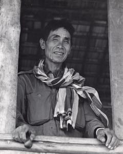 Laven villager in Houei Kong Cluster looking out from his house window in Attapu Province